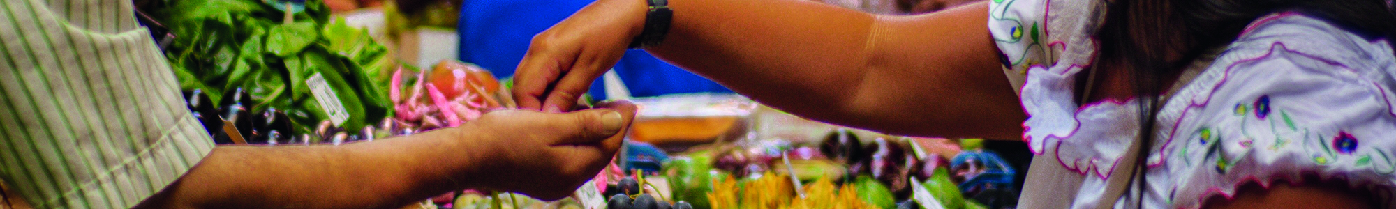 Renate vanaga unsplash 300px Woman paying a man for fresh vegetables at a market stall